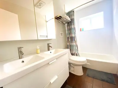 a white bathroom with a sink and a toilet at Tarpon Harbor 1 - Waterfront pool home near beach & downtown Las Olas in Fort Lauderdale