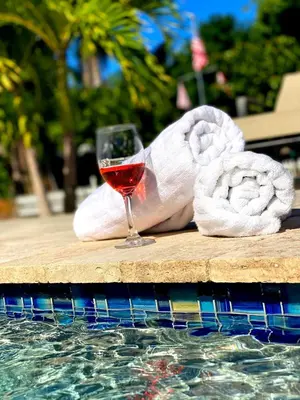 a glass of wine sitting on a table next to a pool at Tarpon Harbor 1 - Waterfront pool home near beach & downtown Las Olas in Fort Lauderdale