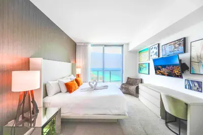a hotel room with a bed and a desk and a desk at Spectacular Sunset Views Over the Ocean at Hollywood in Hollywood