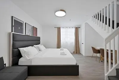 a bedroom with a large bed and a staircase at Sunny Miami Beach Retreat in Miami Beach