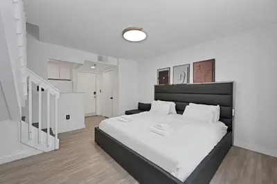 a bedroom with a large bed with white sheets at Sunny Miami Beach Retreat in Miami Beach