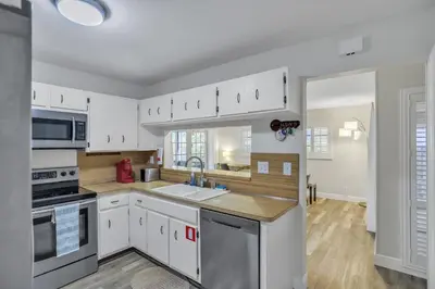 a kitchen with white cabinets and stainless steel appliances at MiaBella of Hollywood home in Hollywood