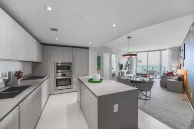 a kitchen with a counter top and a living room at Gorgeous Views Await in Your Beachfront Condo in Hollywood