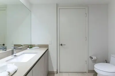 a white bathroom with a toilet and a sink at Gorgeous Views Await in Your Beachfront Condo in Hollywood