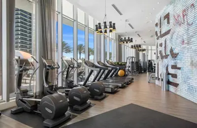 a gym with rows of treadmills and elliptical machines at Luxury Condo with Oceanfront View in Hollywood in Hollywood