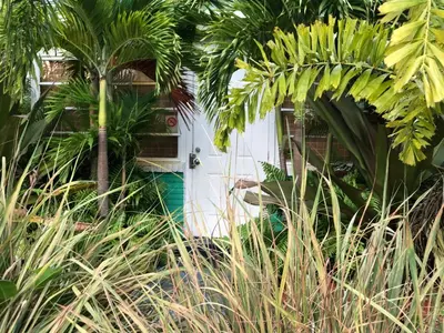 a white caravan with a palm tree in front of it at Calypso Inn Wilton Gay Male Resort in Fort Lauderdale