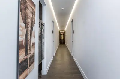 a corridor in a house with white walls and a long hallway at Vive Zen Queen Room in Miami