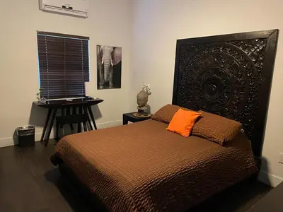 a bedroom with a bed with an orange pillow and a desk at Vive Zen Queen Room in Miami