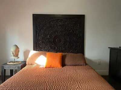 a bedroom with a bed with a large headboard at Vive Zen Queen Room in Miami
