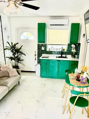 a kitchen with green cabinets and a table at Miami Gardens Comfort Suite by Hard Rock Stadium in Miami Gardens