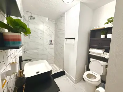 a bathroom with a shower and a toilet and a sink at Miami Gardens Comfort Suite by Hard Rock Stadium in Miami Gardens
