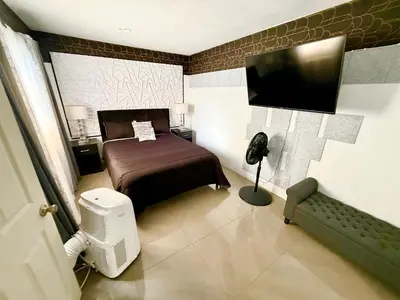 a bedroom with a bed and a flat screen tv at Miami Gardens Comfort Suite by Hard Rock Stadium in Miami Gardens