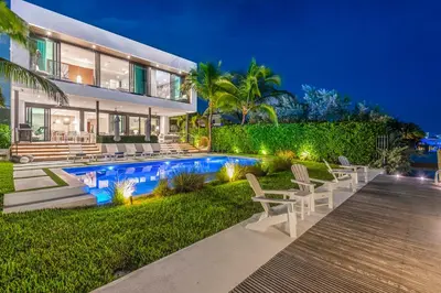 a house with a swimming pool and chairs in the yard at Best Bayfront View New construction w pool in Miami Beach