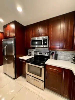 a kitchen with wooden cabinets and stainless steel appliances at Modern Miami Oversized 3 Bedroom in Central Location in Miami