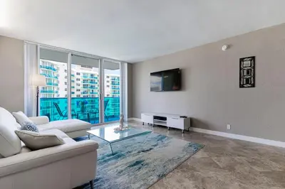 a living room with a couch and a glass table at Ocean View Modern Condo Beach Access 11M in Hollywood