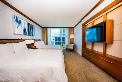 a hotel room with two beds and a flat screen tv at Ocean View Luxury Carillon Condo at Beach Access C616 in Miami Beach