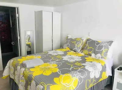 a bedroom with a bed with a yellow and gray blanket at NEW PRIVATE STUDIO MAGIC CITY OF MIAMI, GATED PARKING in Miami