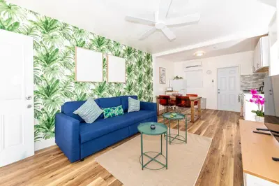 a blue couch in a living room with a tropical wallpaper at Tropic Isle Boutique Hotel in Hollywood