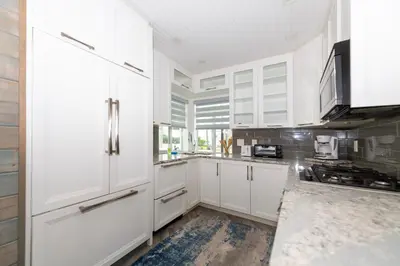 a white kitchen with white cabinets and a sink at Tropic Isle Boutique Hotel in Hollywood