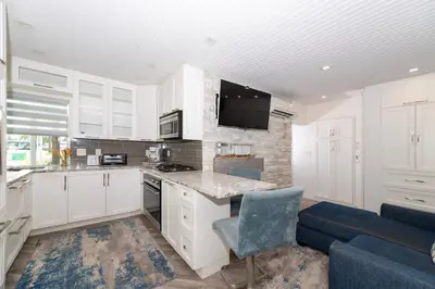 a kitchen with white cabinets and a blue couch at Tropic Isle Boutique Hotel in Hollywood