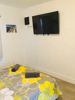 a bedroom with a bed with a flat screen tv on the wall at Home Sweet Home in Miami