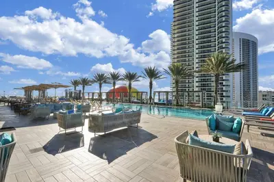 a resort with a pool and palm trees and a building at Chic 2BDR 2BA Water Front in Hyde Beach in Hollywood