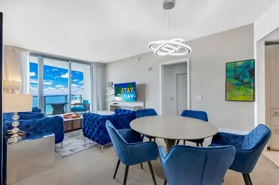 a living room with a table and blue chairs at Heaven Resort - 2BDR BEACH HOME WITH OCEAN VIEW HOLLYWOOD! in Hollywood