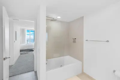 a white bathroom with a tub and a bedroom at Heaven Resort - 2BDR BEACH HOME WITH OCEAN VIEW HOLLYWOOD! in Hollywood