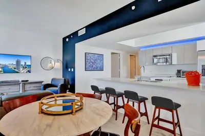 a kitchen and dining room with a table and chairs at Sky-High Spacious Ocean View Condo 4 BDRS 3 BATH in Hallandale Beach