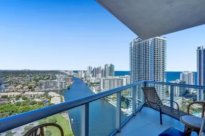 a balcony with a view of a river and buildings at Sky-High Spacious Ocean View Condo 4 BDRS 3 BATH in Hallandale Beach