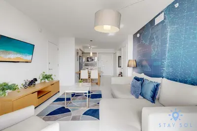 a living room with a white couch and a blue wall at Infinite View - Balcony - Gym - Pool in Hallandale Beach