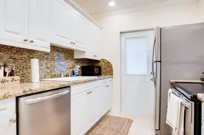 a kitchen with white cabinets and a refrigerator at Intracoastal Oasis in a Prime Area w Pool and BBQ in Fort Lauderdale
