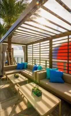 a living room with couches and blue pillows at Direct Oceanfront Condo - Hyde Resort in Hollywood