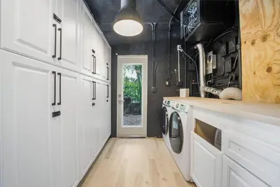 a kitchen with white cabinets and a washer and dryer at Best Bayfront View Heated Pool in Miami Beach