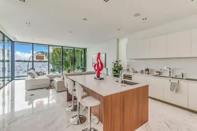 a kitchen with a large island with a red sculpture at Best Sunset Bayfront - pool jacuzzi pool table in Miami Beach