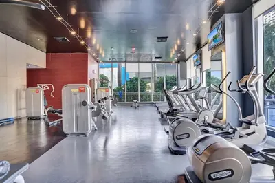 a gym with a bunch of treadmills and machines at Lovely 3 bedroom 3 bathroom ocean front in Hallandale Beach