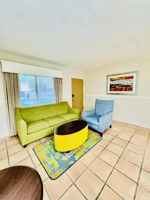 a living room with a green couch and a blue chair at Silver Seas Beach Resort in Fort Lauderdale