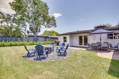 a patio with chairs and tables and an umbrella at Fort Lauderdale Vacation Rental about 8 Mi to Beaches! in Fort Lauderdale