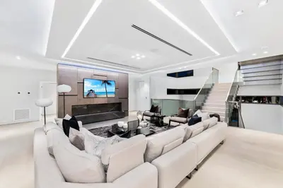 a living room with a white couch and a tv at Park Place Mansion in Fort Lauderdale