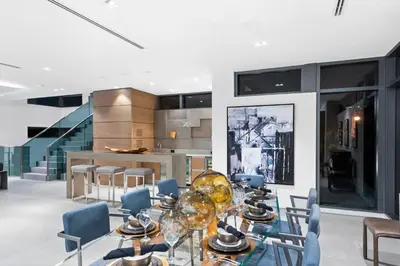 a dining room with a glass table and chairs at Park Place Mansion in Fort Lauderdale