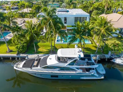 a boat docked in a marina with palm trees at Exquisite Modern Marvel in Golden Isles