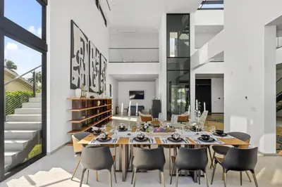 a dining room with a long table and chairs at Exquisite Modern Marvel in Golden Isles