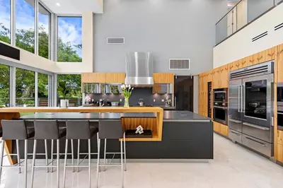 a kitchen with a large island with bar stools at Modani Estates in Miami