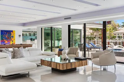 a living room with white furniture and glass walls at Villa Paraiso in Hollywood