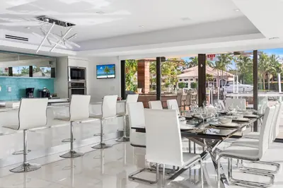 a dining room with a table and white chairs at Villa Paraiso in Hollywood