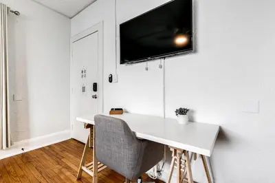 a white desk with a television on a wall at Comfy Little Havana Apt - Centrally located Hv2 in Miami