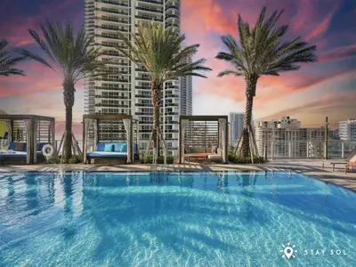 a large swimming pool with palm trees on a building at Rooftop Oceanview Balcony Beachfront Resort in Hollywood
