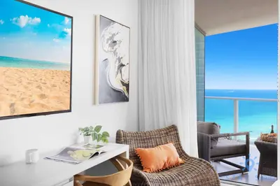 a living room with a table and a chair and a beach at Rooftop Oceanview Balcony Beachfront Resort in Hollywood
