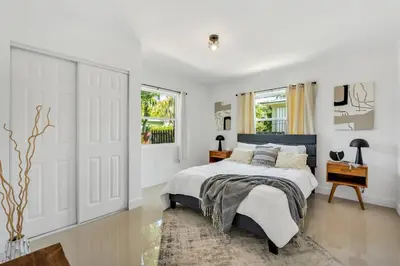 a white bedroom with a bed and a desk at Urban Seaside in Dania Beach
