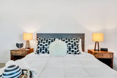 a bedroom with a large white bed with two lamps at Urban Seaside in Dania Beach